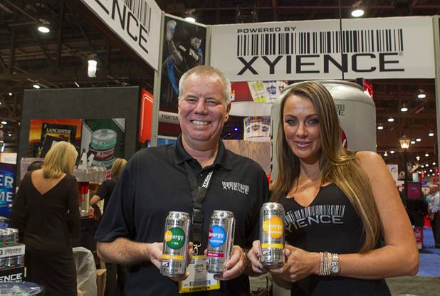 Xyience president John Lennon and former Octagon Girl Amber Nichole Miller display three new non-carbonated energy drinks at the Xyience booth during the annual National Association of Convenience Stores (NACS) trade show at the Las Vegas Convention Center Monday, Oct. 8, 2012. The Hydration drink has no caffeine.