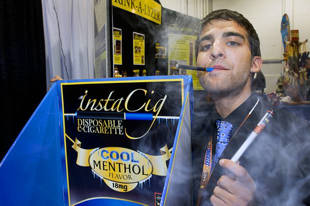 Khushal Rochlani blows out water vapor as he demonstrates the instaCig smokeless cigarette during the annual National Association of Convenience Stores (NACS) trade show at the Las Vegas Convention Center Monday, Oct. 8, 2012.