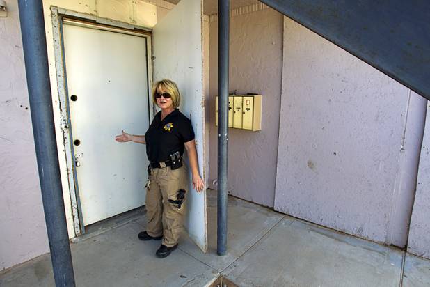 Metro Police Officer Virginia Griffin shows off an apartment door without door knobs during a County Multi-Agency Response Team (CMART) operation at a neighborhood near Twain Avenue and Decatur Boulevard Wednesday, Oct. 10, 2012. Their efforts follow the "broken windows" theory - if a neighborhood can be kept up, it is less likely to have rampant crime.