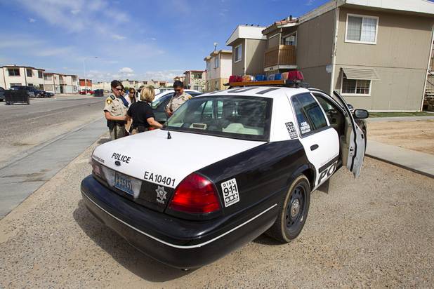 Metro Police officers confer during a County Multi-Agency Response Team (CMART) operation at a neighborhood near Twain Avenue and Decatur Boulevard Wednesday, Oct. 10, 2012. Their efforts follow the "broken windows" theory - if a neighborhood can be kept up, it is less likely to have rampant crime.