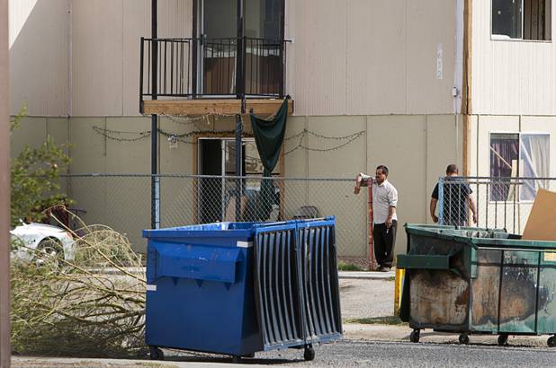 A resident watches as a County Multi-Agency Response Team (CMART) conducts an operation at a neighborhood near Twain Avenue and Decatur Boulevard Wednesday, Oct. 10, 2012. Their efforts follow the "broken windows" theory - if a neighborhood can be kept up, it is less likely to have rampant crime.