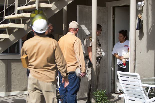 Metro Police Officer Cesar Quesada talks with a resident during a County Multi-Agency Response Team (CMART) operation at a neighborhood near Twain Avenue and Decatur Boulevard Wednesday, Oct. 10, 2012. The woman told police that her unit had no electric power and she was using power from an upstairs unit with the resident's permission.