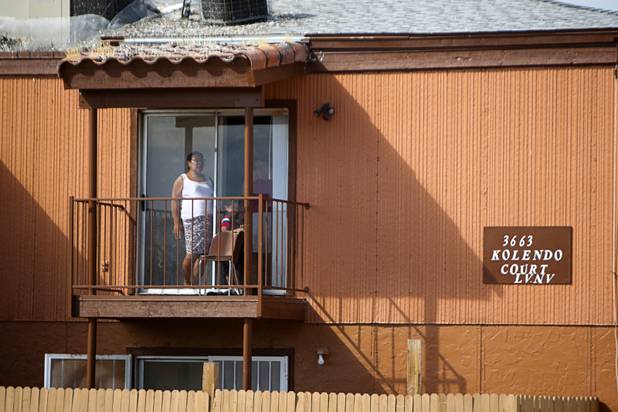 A resident watches from her apartment as a County Multi-Agency Response Team (CMART) conducts an operation at a neighborhood near Twain Avenue and Decatur Boulevard Wednesday, Oct. 10, 2012. Their efforts follow the "broken windows" theory - if a neighborhood can be kept up, it is less likely to have rampant crime.