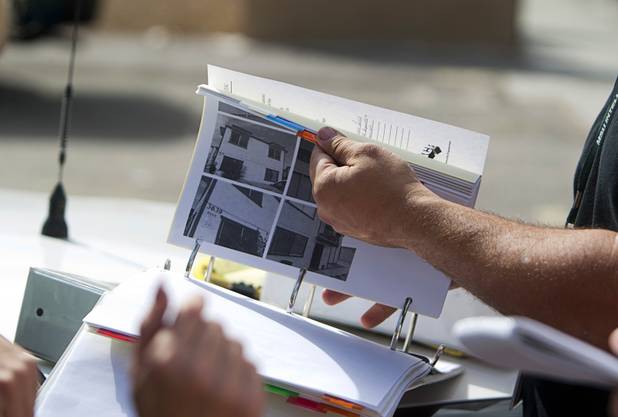 A Metro Police officer looks through a binder of information on a neighborhood near Twain Avenue and Decatur Boulevard during a County Multi-Agency Response Team (CMART) operation Wednesday, Oct. 10, 2012. Their efforts follow the "broken windows" theory - if a neighborhood can be kept up, it is less likely to have rampant crime.