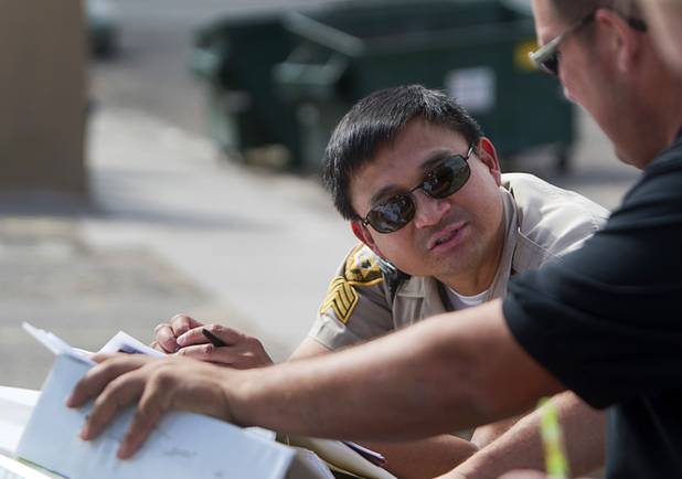 Metro Police Sgt. Geordinno Bagaporo confers with an officer during a County Multi-Agency Response Team (CMART) operation at a neighborhood near Twain Avenue and Decatur Boulevard Wednesday, Oct. 10, 2012. Their efforts follow the "broken windows" theory - if a neighborhood can be kept up, it is less likely to have rampant crime.