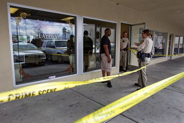 Metro Police officers confer in front of Frank Melaerts Jewelers, 421 S. Decatur Blvd., after the store was robbed at gunpoint Wednesday, Oct. 9, 2012. 