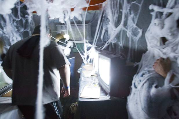 Guess make their way through a room at the Amazing Jonathan's SCREAMont Experiment haunted hotel at the Las Vegas Club in downtown Las Vegas Thursday, Oct. 10, 2012. The haunted hotel is open nightly from 7 p.m. to midnight.