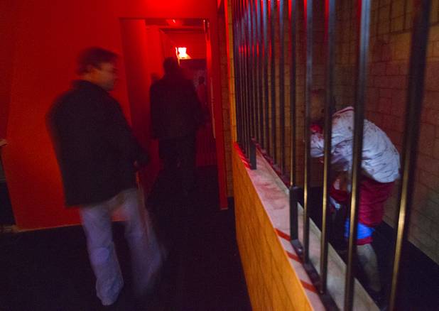 Guests pass by what appears to be a casino cage during a VIP/media night event at the Amazing Jonathan's SCREAMont Experiment haunted hotel at the Las Vegas Club in downtown Las Vegas Thursday, Oct. 10, 2012. The haunted hotel is open nightly from 7 p.m. to midnight.