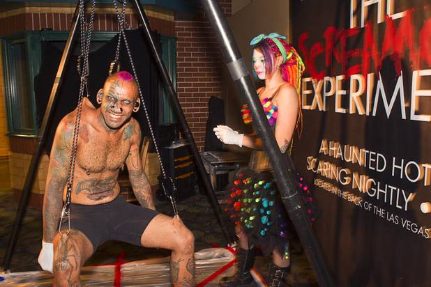Supa Niga of the SwingShift SideShow hangs from hooks attached to his back and thighs during a VIP/media night event at the Amazing Jonathan's SCREAMont Experiment haunted hotel at the Las Vegas Club in downtown Las Vegas Thursday, Oct. 10, 2012. Oxi Lox, right, stands by to give him an occasional swing. The haunted hotel is open nightly from 7 p.m. to midnight.