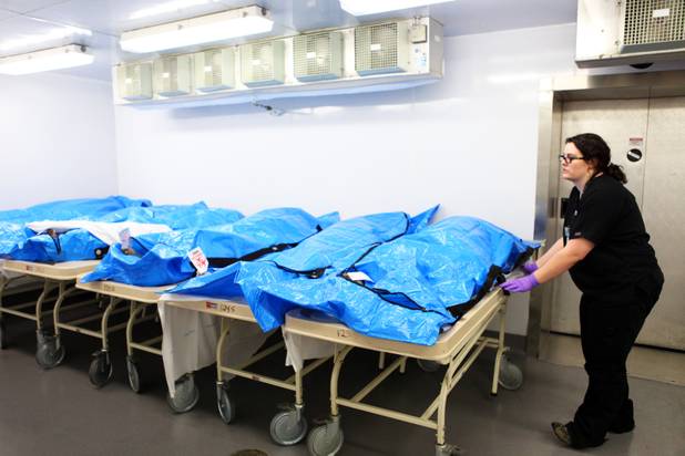 Forensic assistant Lindsay Hanes lines up the body of a newly arrived decedent with the other bodies in the cooler at the Clark County Office of the Coroner/Medical Examiner in Las Vegas.