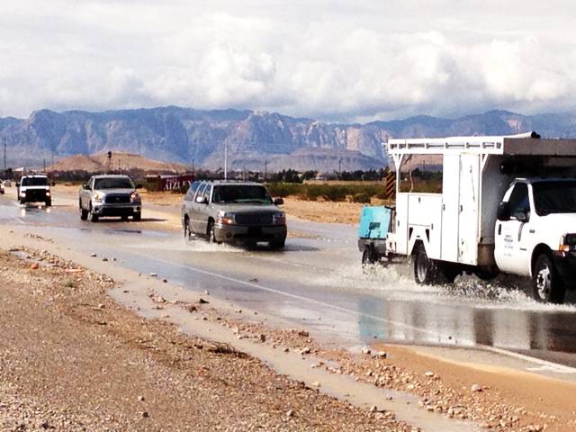 Traffic plows through water flowing across Silverado Ranch Boulevard west of Dean Martin Drive on Friday after heavy storms swept through the Las Vegas Valley on Thursday, Oct. 11, 2012.