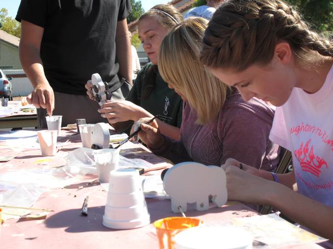 Teens at the Green Valley Church of Jesus Christ of Latter-day Saints assemble wooden toys to be donated to charity for their Day of Service community project on Saturday. 