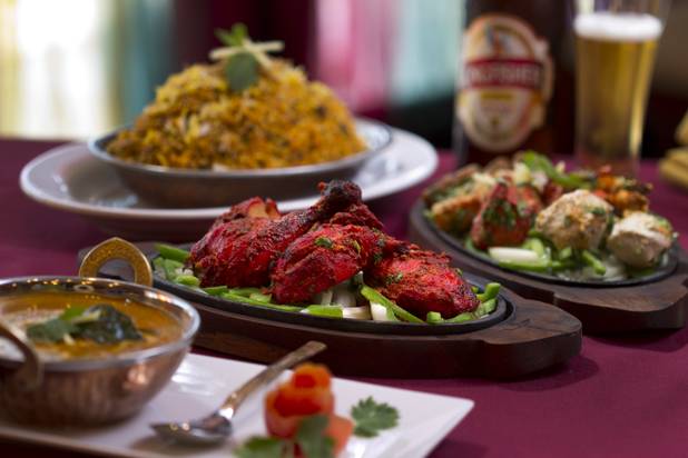 Tandoori chicken, center, at Saffron Flavors of India restaurant, 4450 N. Tenaya Way, Sunday, Oct. 14, 2012. Also pictured, clockwise from top right, Saffron biryabi, a mixed Saffron platter, and Chicken Madras curry.
