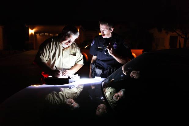 Coroner investigator Richard Jones speaks with responding North Las Vegas Police Officer Loran McAlister outside of the scene where a dead body was found in North Las Vegas.