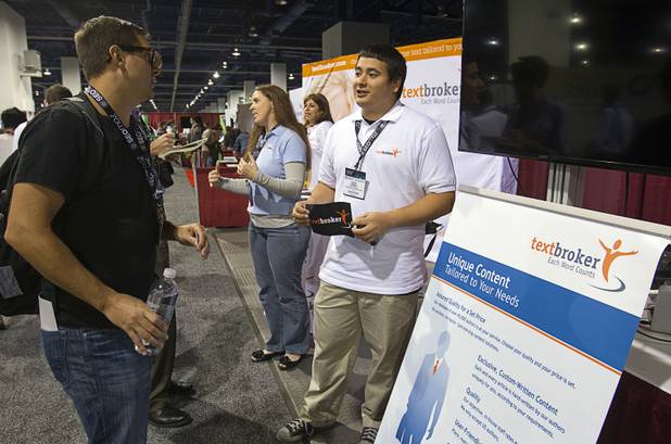 David Brown, left, director of Allied Health Media, listens to Josh Jenne of Textbroker International during PubCon, a social media and optimization conference, at the Las Vegas Convention Center Wednesday, Oct. 17, 2012.