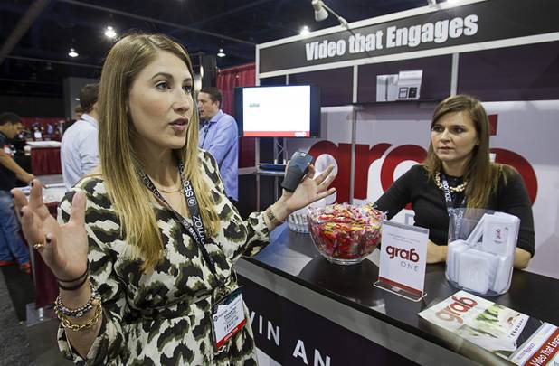 Samantha Dascher, manager of business development for Grab Media, describes the company's services during PubCon, a social media and optimization conference, at the Las Vegas Convention Center Wednesday, Oct. 17, 2012.