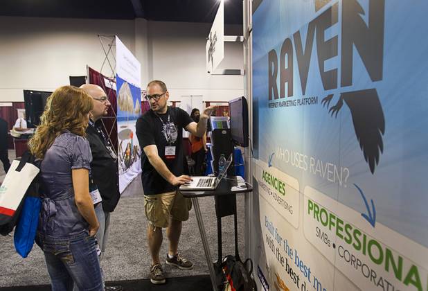 Jon Henshaw, center, co-founder and CPO of Raven Internet Marketing Tools, talks with attendees during PubCon, a social media and optimization conference, at the Las Vegas Convention Center Wednesday, Oct. 17, 2012.
