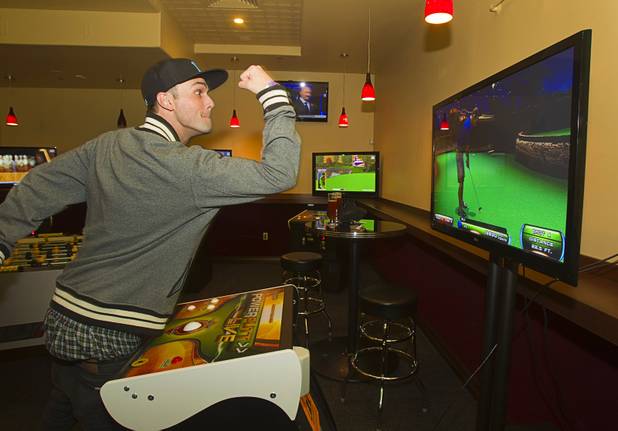 Evan Toepfert reacts to his putt while playing a golfing game in the Players Club, a bar at Stephanie Street and Paseo Verde Parkway, in Henderson Thursday, Oct. 18, 2012.