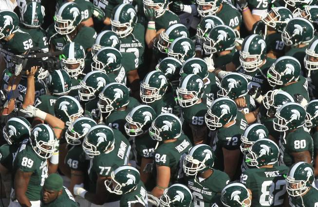 The Michigan State football team meets at midfield before during the first quarter of an NCAA college football game Ohio State at Spartan Stadium in East Lansing, Mich., Saturday, Sept. 29, 2012.