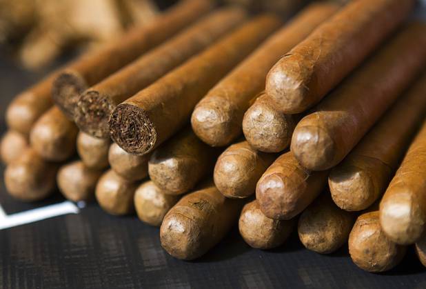 Cigars are stacked on a table during a private party in the Foundation Room at the Mandalay Bay Sunday, Oct. 21, 2012. Cigar Dolls is a company that provides attractive cigar rollers for corporate events or private parties.