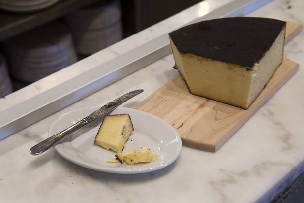 A wedge of cheese from a Utah cheese maker is displayed at Honey Salt, a new restaurant at 1031 S Rampart Blvd, Monday, Oct. 22, 2012.  The cheddar style cheese has a rind of finely ground espresso coffee beans, lavender and vegetable oil.