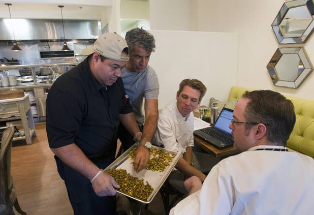 Cook Daniel Cossio holds a tray of California pistachios for chefs Kim Canteenwalla, Sean Kahlenberg, center, and Joe Zanelli at Honey Salt, a new restaurant at 1031 S Rampart Blvd, Monday, Oct. 22, 2012.