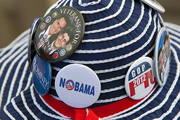 A woman wears buttons on her hat showing her support for Republican presidential candidate Mitt Romney and running mate Paul Ryan during a campaign rally at the Henderson Pavilion Tuesday, Oct. 23, 2012.