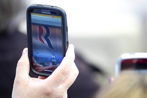 A supporter uses his phone to take a video of Republican presidential candidate Mitt Romney and running mate Paul Ryan during a campaign rally at the Henderson Pavilion Tuesday, Oct. 23, 2012.