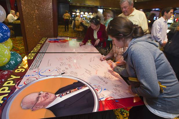 Well-wishers sign a card for Las Vegas gaming pioneer Jackie Gaughan during his 92nd birthday with a champagne and cake celebration at El Cortez in downtown Las Vegas, Wednesday, Oct. 24, 2012.