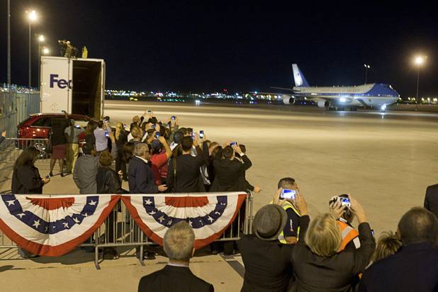 Friends and family guests watch as Air Force One taxis arriving at McCarran International Airport Wednesday, Oct. 24, 2012.