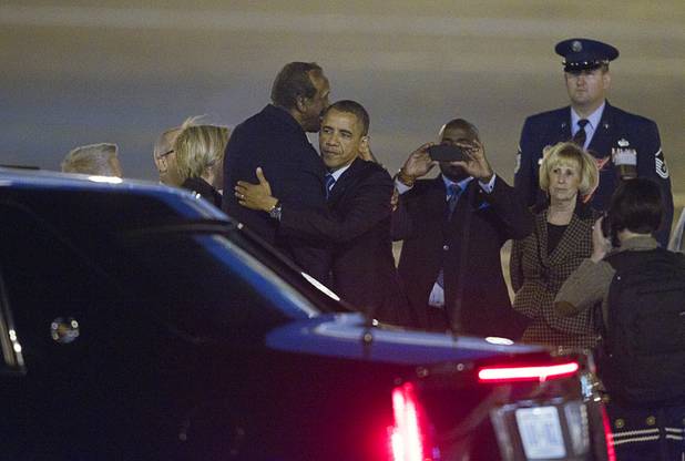 President Barack Obama gives a hug to State Assemblyman Harvey Munford waves after arriving at McCarran International Airport Wednesday, Oct. 24, 2012.