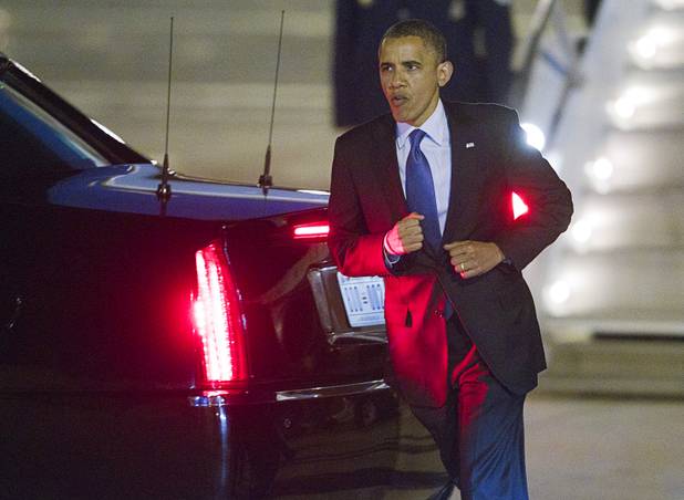 President Barack Obama jogs to greet friends and family guests after arriving at McCarran International Airport Wednesday, Oct. 24, 2012.