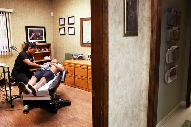 Technician Magdelyn Vasquez-Castro removes a tattoo from the stomach of ...
