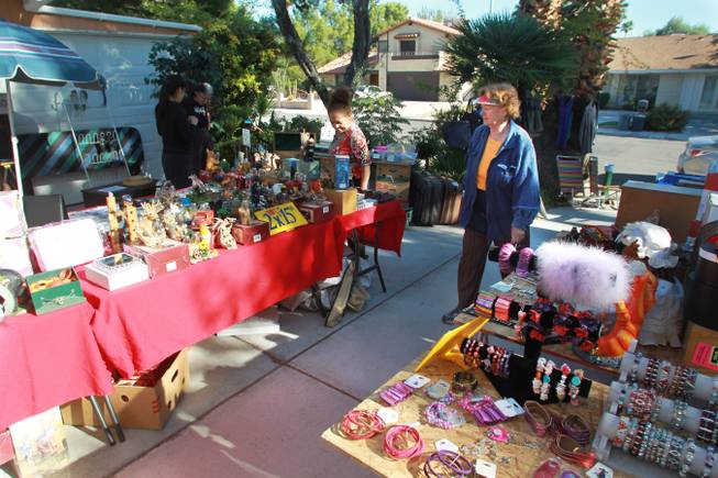 Nadine Bezard surveys her garage sale in the Paradise Palms neighborhood Saturday, Oct. 20, 2012.