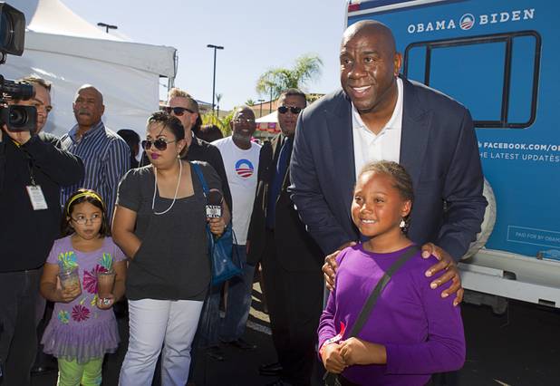 Basketball legend Earvin "Magic" Johnson poses for photos as he campaigns for President Obama during an Asian American and Pacific Islander early voting rally at the Chinatown Mall on Saturday, Oct. 27, 2012.