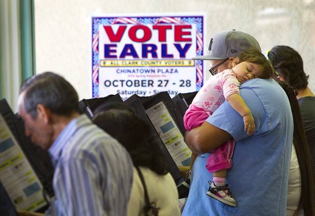 Michael Streeter participates in early voting as his 14-month-old daughter naps at the Chinatown Mall on Saturday, Oct. 27, 2012.