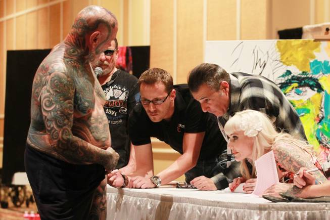 Milwaukee resident David Zielinski displays recent work for judges Mike Ehrmann, Paul Gambino and Sabina Kelley during a contest at Mario Barth's Biggest Tattoo Show on Earth at the Mirage on Saturday, Oct. 27, 2012.