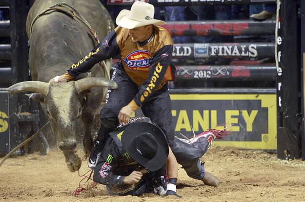 Bullfighter Frank Newsom distracts a bull to protect Brazilian bull rider Robson Palermo during the Built Ford Tough Series Professional Bull Riders (PBR) World Finals at the Thomas & Mack Center Sunday, Oct. 28, 2012. Palermo won the Las Vegas event. Brazilian Silvano Alves took the series championship. 