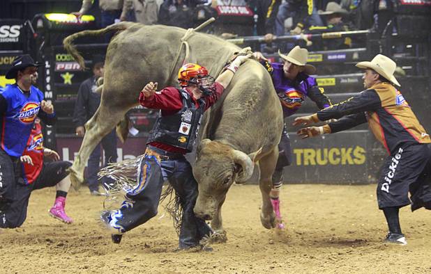 Bullfighters move in to help Chris Shivers of Jonesville, La. after Shivers' hand got caught in the rope during the Built Ford Tough Series Professional Bull Riders (PBR) World Finals at the Thomas & Mack Center Sunday, Oct. 28, 2012. Shivers retired Sunday after making a PBR-record 15th World Finals appearance.