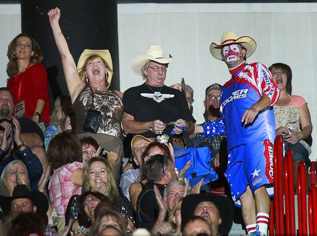 A woman cheers as entertainer Flint Rasmussen moves the couple from the cheap seats to the front row during the Built Ford Tough Series Professional Bull Riders (PBR) World Finals at the Thomas & Mack Center Sunday, Oct. 28, 2012.