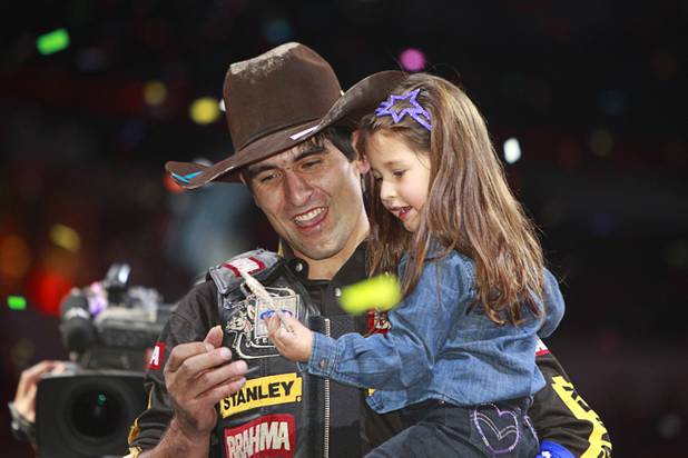 Brazilian bull rider Silvano Alves and his daughter Hanyelle, 3, look over his championship buckle after Alves won the series championship during the Built Ford Tough Series Professional Bull Riders (PBR) World Finals at the Thomas & Mack Center Sunday, Oct. 28, 2012. Alves is the first rider to win back-to-back series championships in PBR.