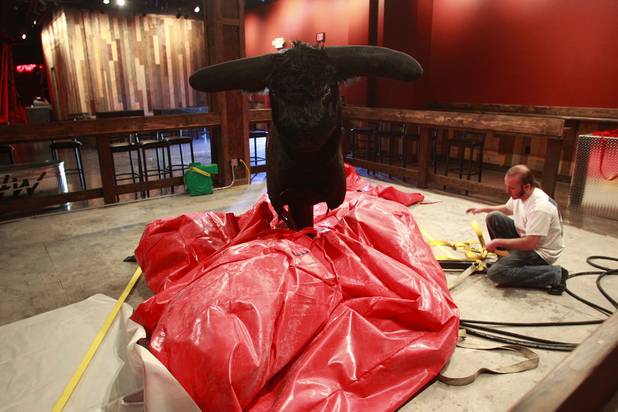 A technician works on a mechanical bull at Stoney's Rockin' Country's new location in Town Square Tuesday, Oct. 30, 2012.