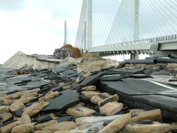 Storm-driven waves from superstorm Sandy destroyed an approach road to the old bridge spanning the Indian River Inlet in southern Delaware. The new bridge, seen in the background, was undamaged but remained closed to traffic Tuesday, Oct.30, 2012, after waves destroyed hundreds of yards of beach dunes and left state Route 1 covered with sand. (AP Photo/Randall  Chase)