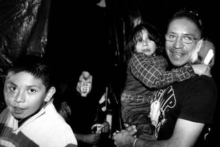 Arturo Martinez-Sanchez takes his sons Cristopher, left, 10, and Alejandro, 5, through a haunted house while trick-or-treating with friends from his old neighborhood in Las Vegas on  Oct. 31, 2012.
