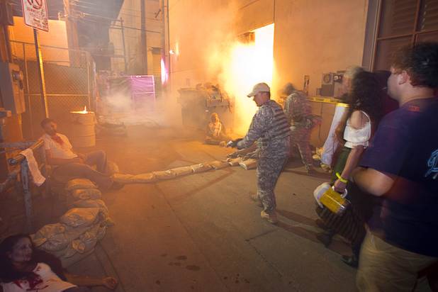 A guide dressed in a military uniform leads a group through the Haunted Alley during Halloween in downtown Las Vegas Wednesday, October 31, 2012.