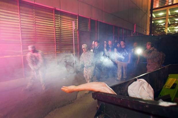 Guides dressed in a military uniforms leads a group through the Haunted Alley during Halloween in downtown Las Vegas Wednesday, October 31, 2012.
