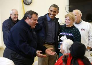 President Barack Obama, center, and the Federal Emergency Management Administration's Craig Fugate, left, watch as New Jersey Gov. Chris Christie, second from left, meets with residents at Brigantine Beach Community Center on Wednesday, Oct. 31, 2012, in Brigantine, N.J.