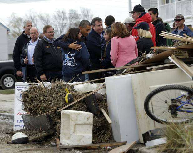 President Barack Obama, center, and and Gov. Chris Christie meet with local residents as they tour neighborhood effected by superstorm Sandy, Wednesday, Oct. 31, 2012 in Brigantine, N.J. Also with them is Sen. Bob Menendez, D-N.J., left. (AP Photo/Pablo Martinez Monsivais)