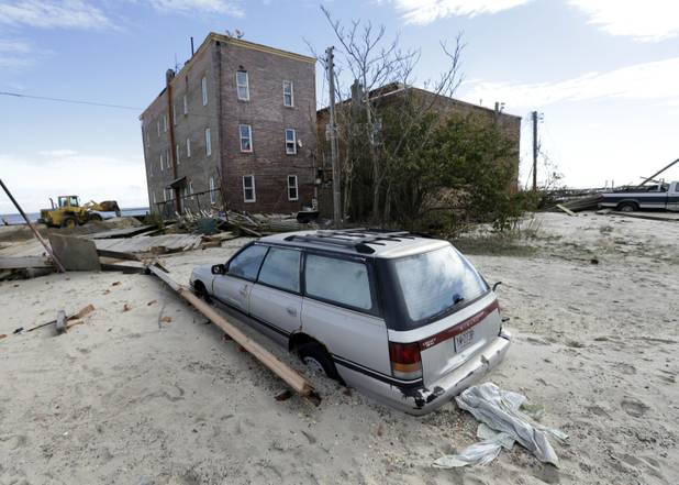 A car is partially buried by sand that was washed ashore by superstorm Sandy in Atlantic City, N.J.,on  Wednesday, Oct. 31, 2012.