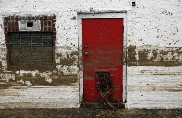 Sand marks the floodwater line on the side of a house in the aftermath of superstorm Sandy, Tuesday, Oct. 30, 2012, in Long Beach, N.Y.  Sandy, the storm that made landfall Monday, caused multiple fatalities, halted mass transit and cut power to more than 6 million homes and businesses. (AP Photo/Jason DeCrow)